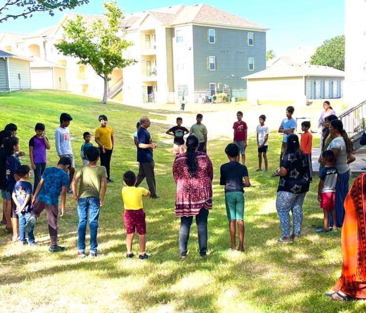 An outdoor community learning session on the lawn