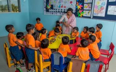 Pre-school children working with their teacher at an activity table