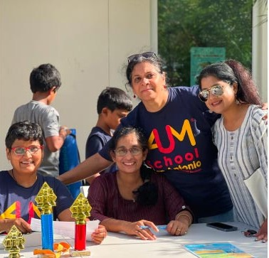 Families building geometric craft models at an Aum School event