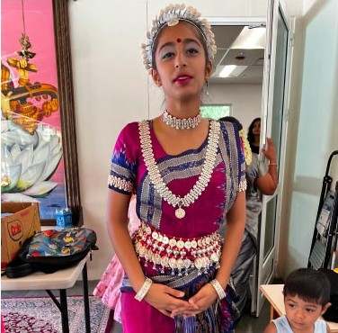 A student in classical dance costume before a performance
